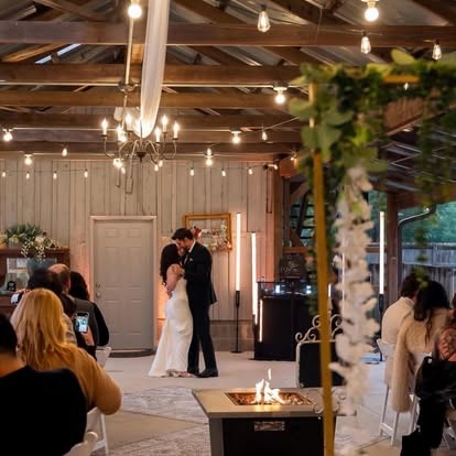 Couple sharing their first dance in a candlelit barn venue
