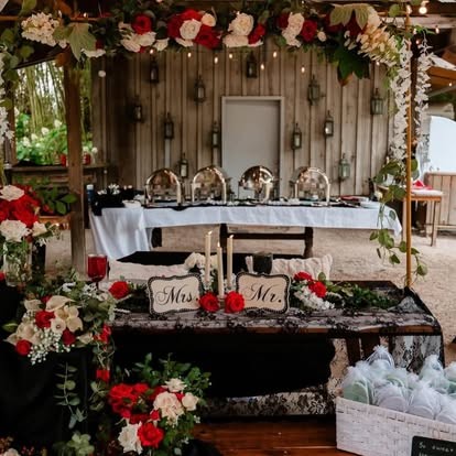 Sweetheart table with Mr and Mrs signs, red roses, white florals and black lace linens